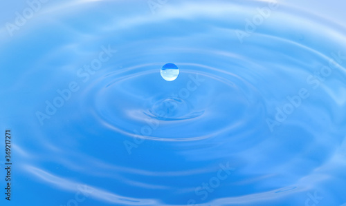water droplets fall down closely into the blue water, making it the perfect center in nature.