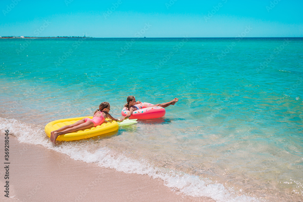 Little girls having fun at tropical beach during summer vacation playing together Little girls having fun at tropical beach during summer vacation playing together