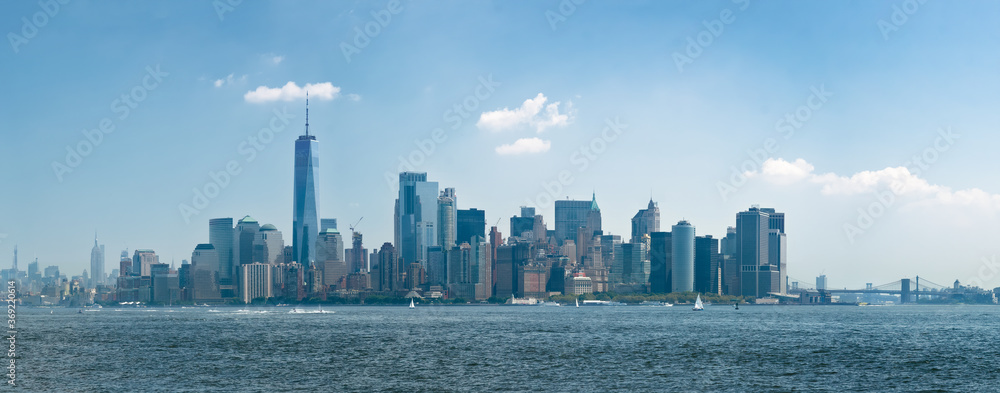 Panorama manhattan skyline from hudson river with blue sky and summer cloud from liberty island. New-York, United States.