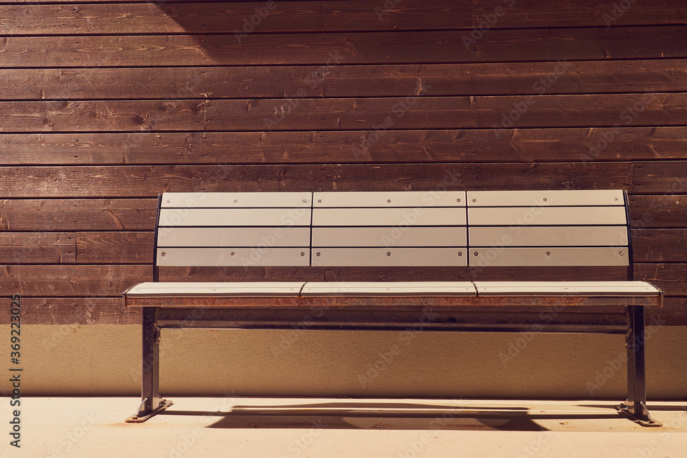 A metallic bench at the wooden wall. Copy space. A metallic bench at the wooden wall. Copy space.