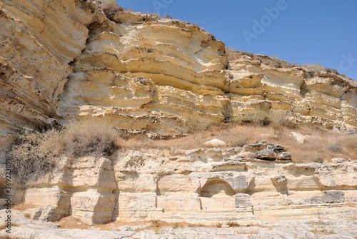 Edge of Kourion plateau with chamber tombs consisting of cist burials cut into the quarried rock shelf of the Neolithic period Kourion Ancient city on the southwestern coast of Cyprus © Nigar