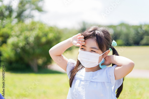 マスクをして暑さに苦しむ子供