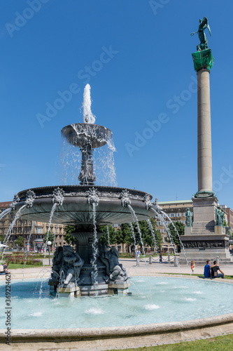 view of the Schlosspark area in downtown Stuttgart with a male couple by the fountains