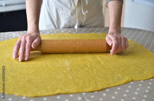Hands baking dough with rolling pin on the table © sergnester