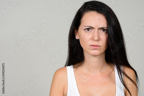 Portrait of stressed woman against white background