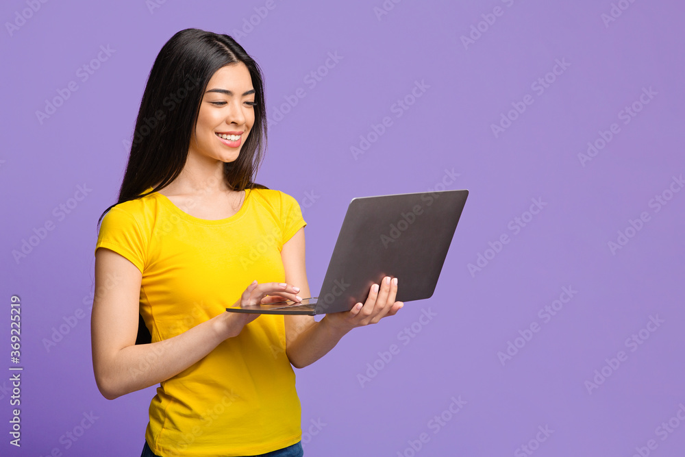 Online Education. Smiling Asian Girl Using Laptop Computer Over Purple Background Online Education. Smiling Asian Girl Using Laptop Computer Over Purple Background