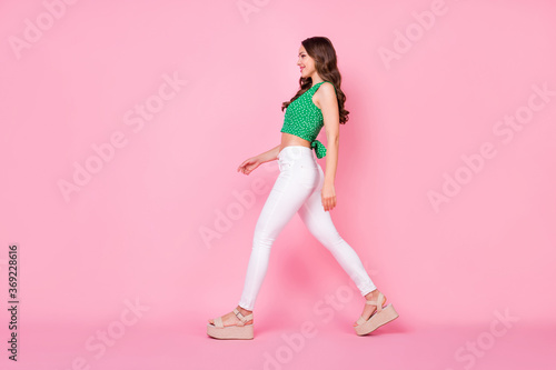 Full size profile side photo of attractive nice girl go walk copyspace enjoy meet her friend wear good look clothes isolated over pastel color background