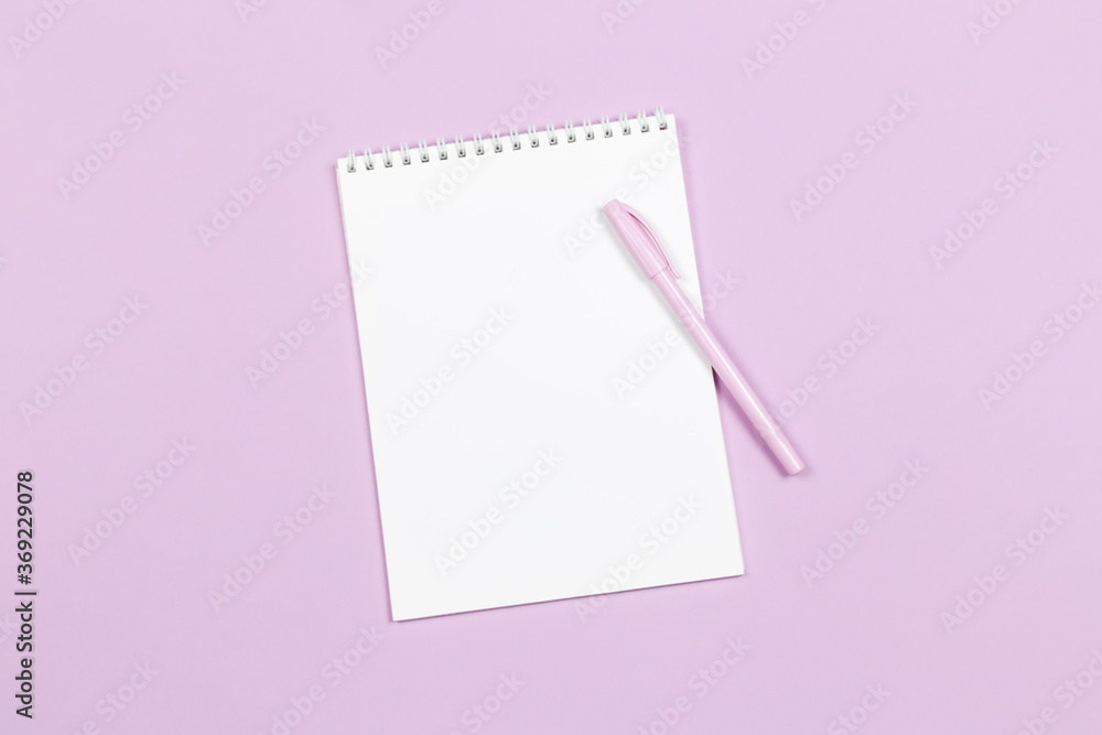Notebook with blank page and pen on a violet pastel background. Notebook with blank page and pen on a violet pastel background.