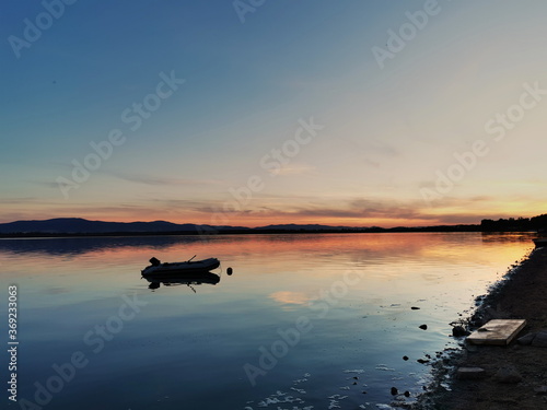 Sunset on the lake. A pontoon on the lake surface during sunset. Otmuchow Poland. © Tomek