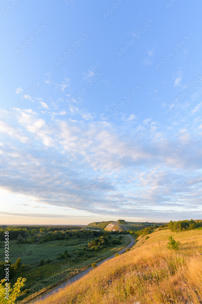 Fototapeta premium chalk mountains and river at sunrise. early summer morning . panorama of the natural landscape