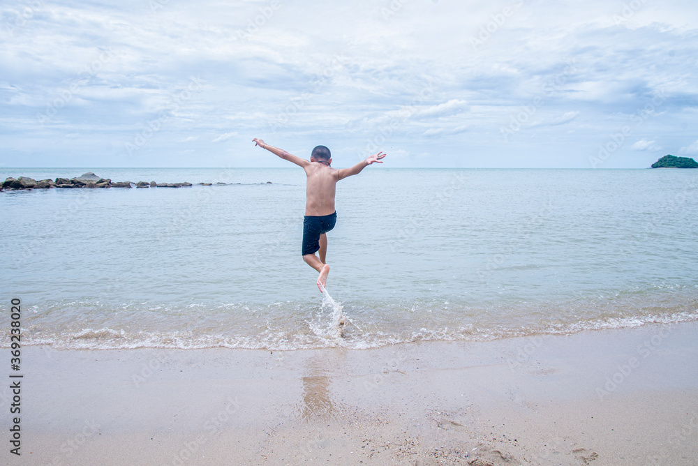 happy boy running into the sea