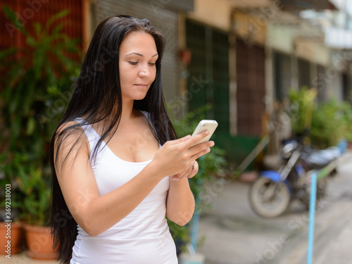 Wallpaper Mural Portrait of beautiful woman using phone outdoors Torontodigital.ca