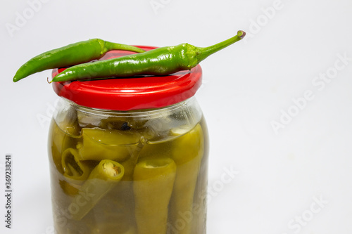 Homemade marinated chili peppers on a white background