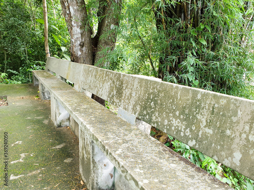 Relaxing seats, stone chairs in the park, with abundant trees and green grass. landscape garden with stone seats. Fresh air in the park.