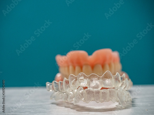 A DENTURE FITTING THE INVISALING BRACES ON A BLUE BACKGROUND WITH COPY-SPACE photo