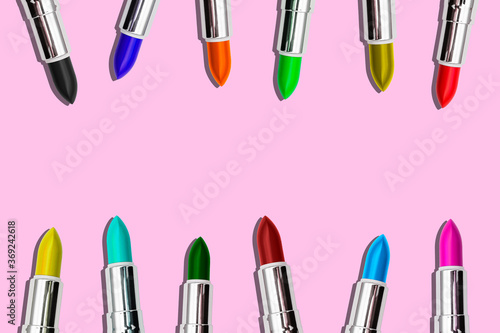 Set of colored lipstick on a pink background. Cosmetic product. Minimal style. Top view with a copy of the space.