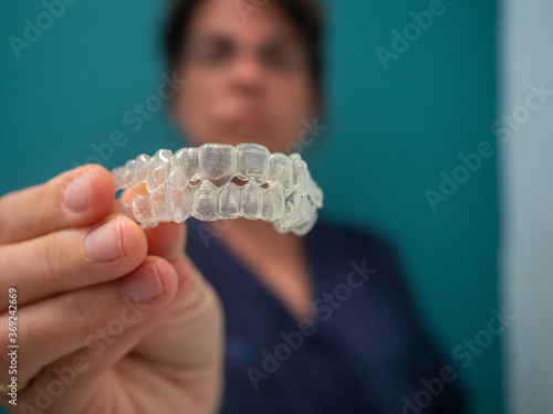 AN UNFOCUSED WOMAN HOLDS AN INVISALING BRACES photo