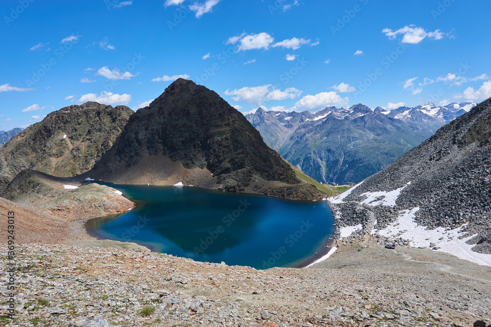 Obraz premium Bergsee in den Bergen mit blauem klaren erfrischendem Wasser aus Gletscher in Tirol