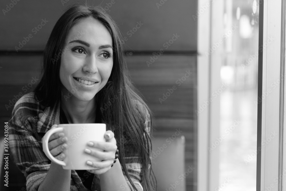 Portrait of young beautiful hipster woman at the coffee shop in black and white
