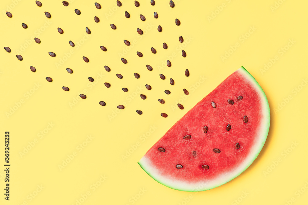 Watermelon slice with seeds on yellow background. food art Watermelon slice with seeds on yellow background. food art