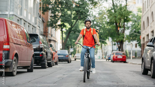 Wallpaper Mural Express delivery service. Cyclist with helmet and yellow backpack rides on road Torontodigital.ca