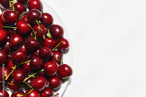 Ripe sweet cherries on plate isolated on white background with copy space