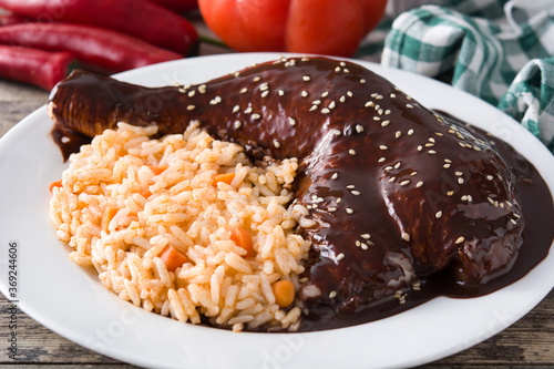 Traditional mole Poblano with rice in plate on wooden table.Close up	 photo