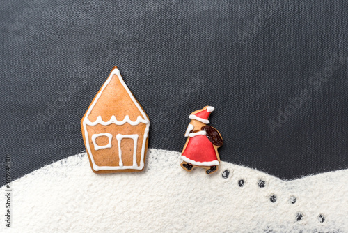Lebkuchenhaus im Schnee mit Weihnachtsmann auf schwarzem Hintergrund