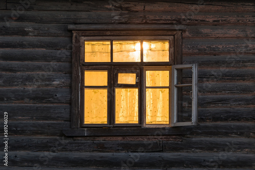Window of the wooden ancient house at night time.