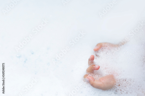 baby hands playing with bubble while bathing