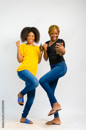 young black beautiful ladies jubilating over something they received on their smartphones photo