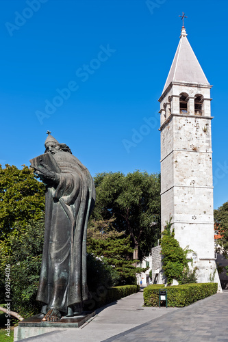 Gregory of Nin statue and bell tower in Split - Dalmacia, Croatia. Because of the popular belief that rubbing the bishop's toe brings good luck, the toe is now smooth and shiny. photo