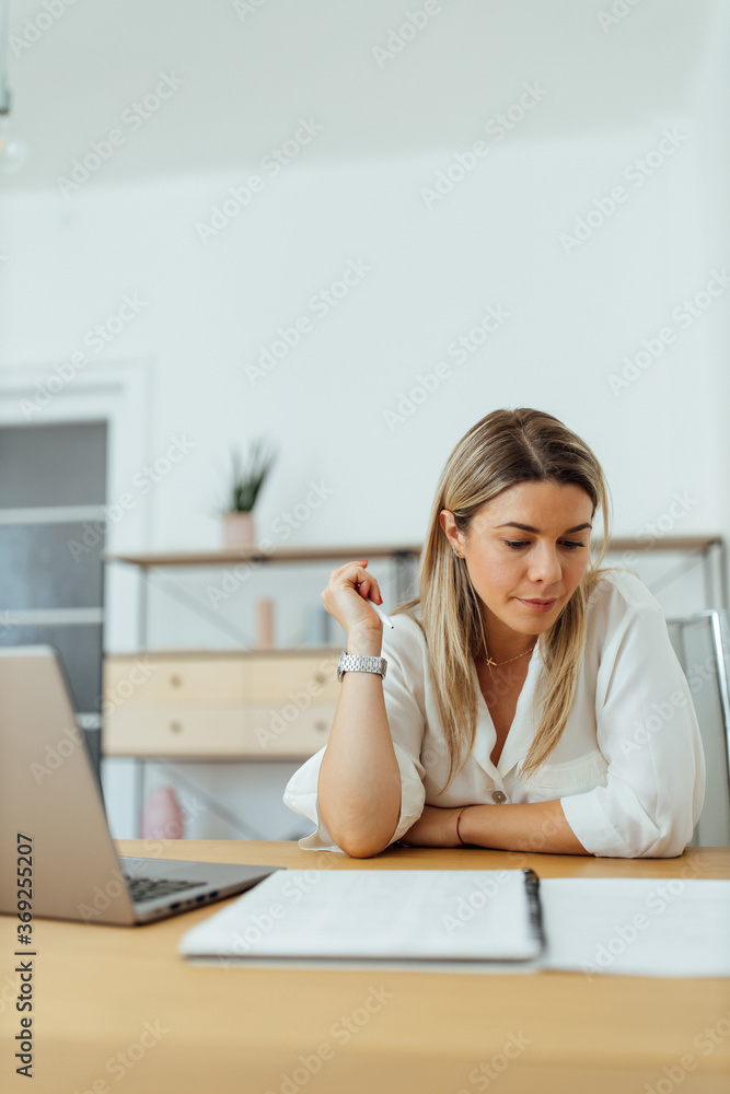 Portrait of a serious woman reading report or doing home finances. Portrait of a serious woman reading report or doing home finances.