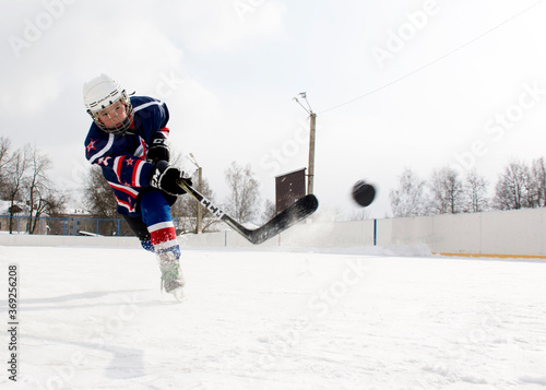 Canvas Print The boy plays hockey on the street