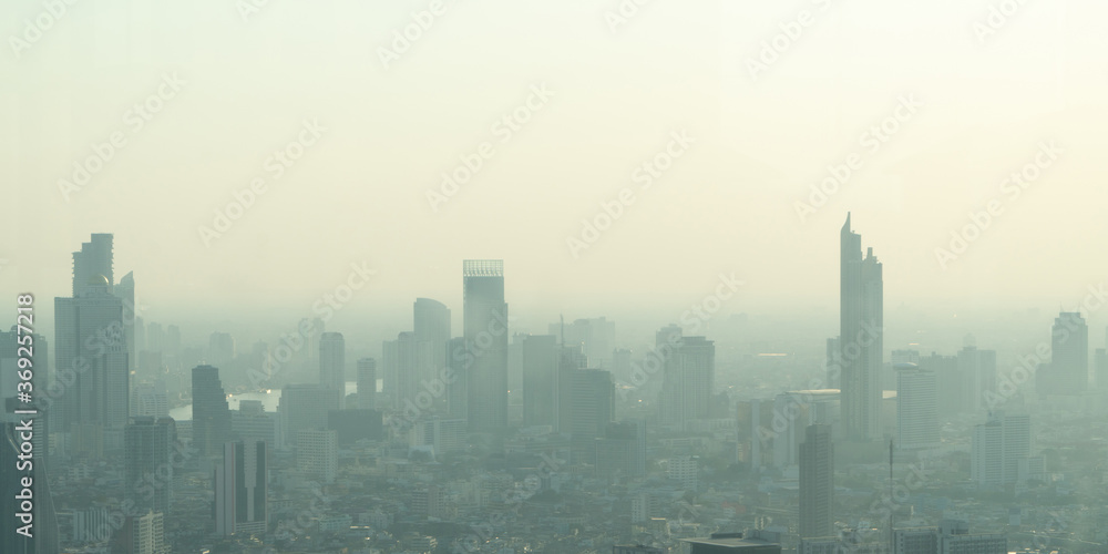 Obraz premium Concept of Pollution PM2.5 Unhealthy air pollution dust. Toxic haze in the city. Photos in the capital on a skyscraper.