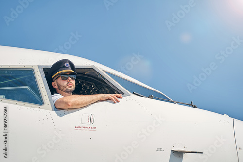 Photo Serious calm airman sitting in a cockpit