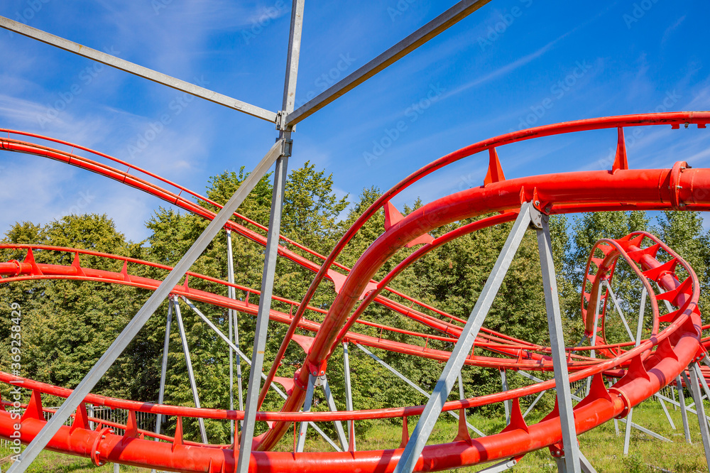 Roller coaster in an amusement park on a blue sky background on a sunny summer day Roller coaster in an amusement park on a blue sky background on a sunny summer day