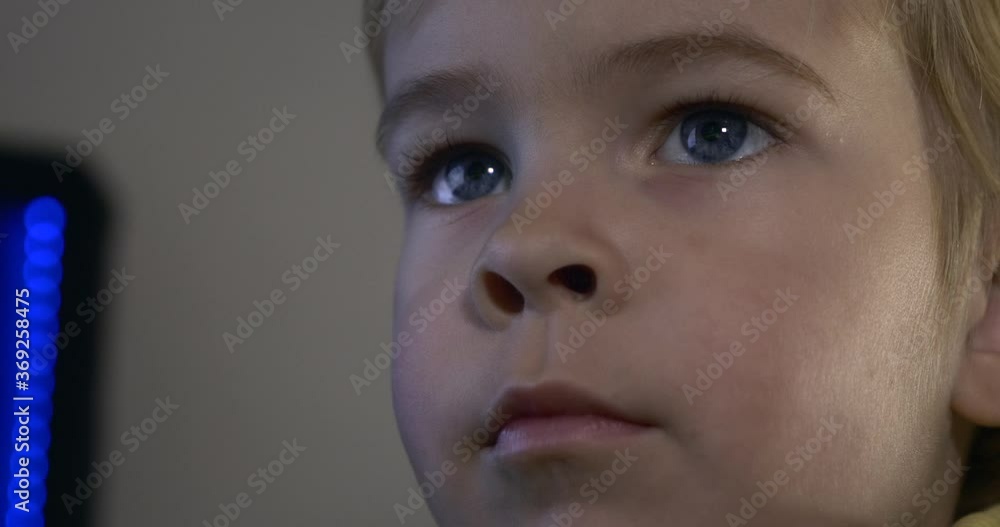 Cute Child is Using Computer Surfing Internet. Monitor Screen Reflection in Blue Eyes Cute Child is Using Computer Surfing Internet. Monitor Screen Reflection in Blue Eyes