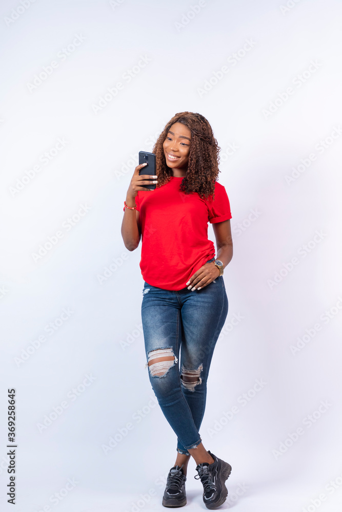 young pretty african lady looking at her phone young pretty african lady looking at her phone