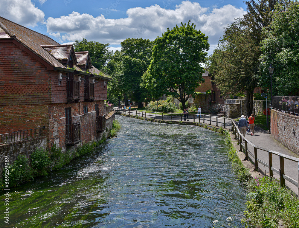 River Itchen in Winchester flowing between the river walk and medieval buildings.