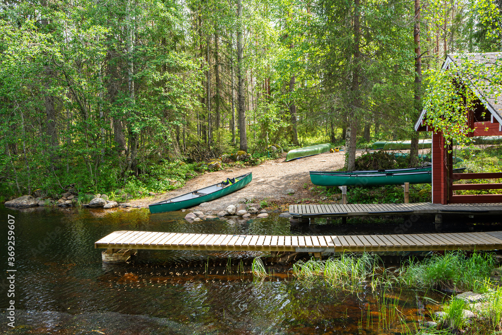 Wooden boat pier and canoe on the shore of the canyon lake Julma-Olkky, Hossa National Park, Kuusamo, Finland Wooden boat pier and canoe on the shore of the canyon lake Julma-Olkky, Hossa National Park, Kuusamo, Finland