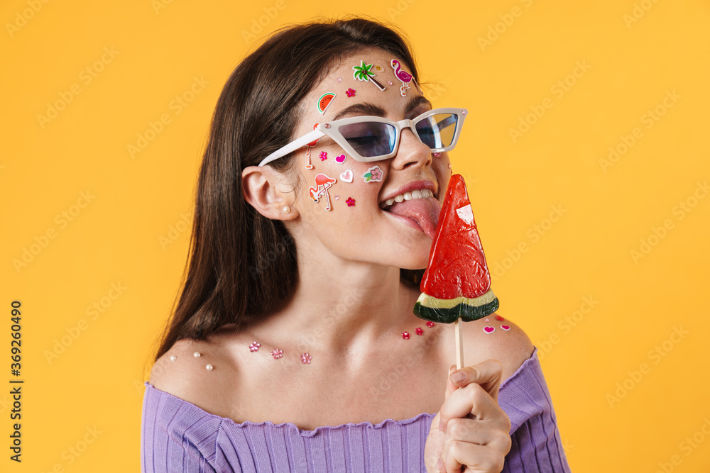 Image of young funny woman liking lollipop and smiling Image of young funny woman liking lollipop and smiling
