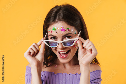 Image of joyful woman wearing sunglasses smiling at camera