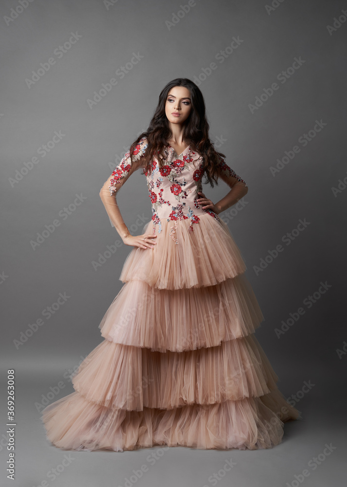 Beautiful bride on gray background. Portrait of a Bride in beautiful wedding dress.