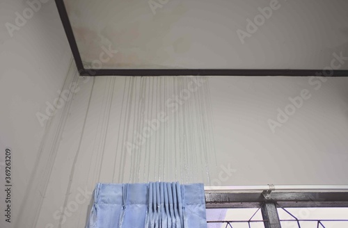 Water stains on the wall.Water flows from the ceiling to the interior of the room.copy space.Rainwater flows through the walls of his room, storms, drought, roof damage, strong currents