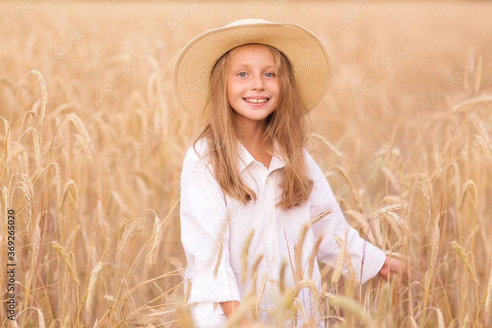 Adorable little girl in a straw hat in wheat field. Child with long ...