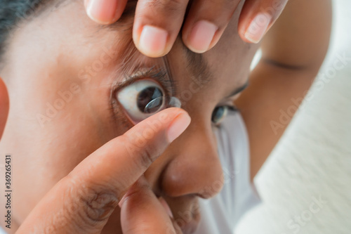 Woman putting on on contact lenses