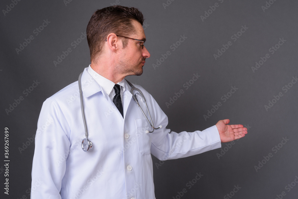 Portrait of handsome bearded man doctor against gray background Portrait of handsome bearded man doctor against gray background