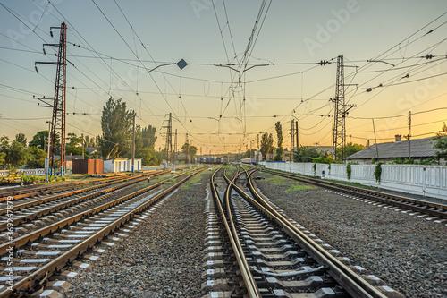 Railroad switch lines diverging in different directions at the station in the evening at sunset.
