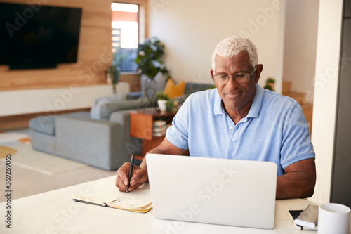 Senior African American Man Using Laptop To Check Finances At Home
